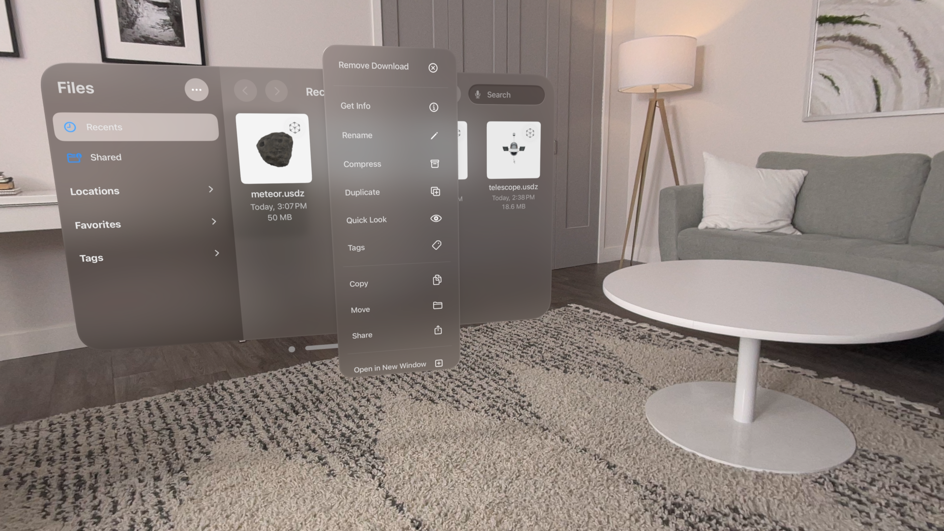 A recording that shows a wearer dragging a 3D file named meteor out of a Finder window. The wearer drags the file into empty space, dropping it in an area that's visually near a table in their physical surroundings. The dropped file opens, showing a 3D meteor that appears to float above the table.