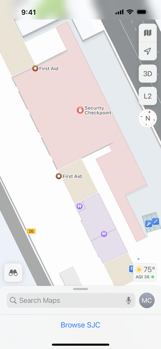A screenshot of a map on iPhone, displaying a close-up view of a terminal at the San Jose International airport. A security checkpoint, first aid stations, restrooms, an escalator, and a gate number are displayed on the map. A minimized card containing a search field and a Browse SJC button is visible at the bottom of the screen.