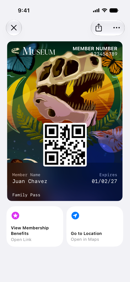A screenshot of a museum membership pass open in Wallet on iPhone, showing a full-art background with a dinosaur skull illustration, a QR code, and member details. Below the pass are two featured actions: View Membership Benefits and Go to Location.